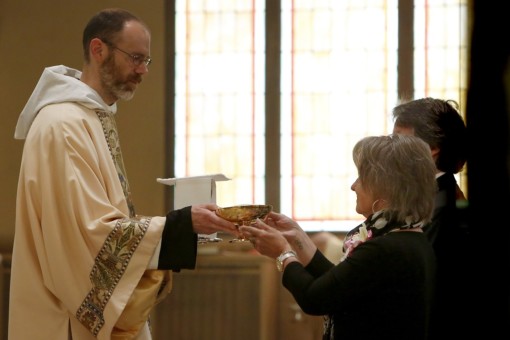Br. Joseph receives the gifts from Fr. Timothy's parents during the offertory.